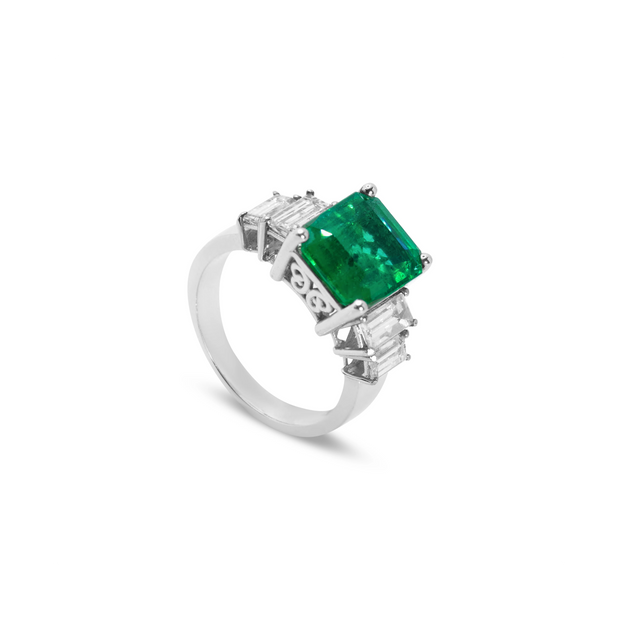 Angled view of 18ct white gold Colombian emerald ring with natural diamond surround in a timeless, elegant setting.