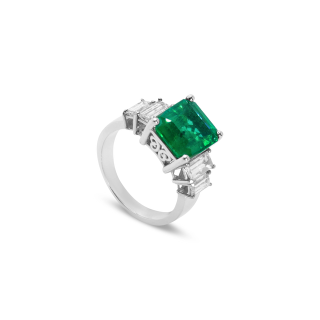 Angled view of 18ct white gold Colombian emerald ring with natural diamond surround in a timeless, elegant setting.