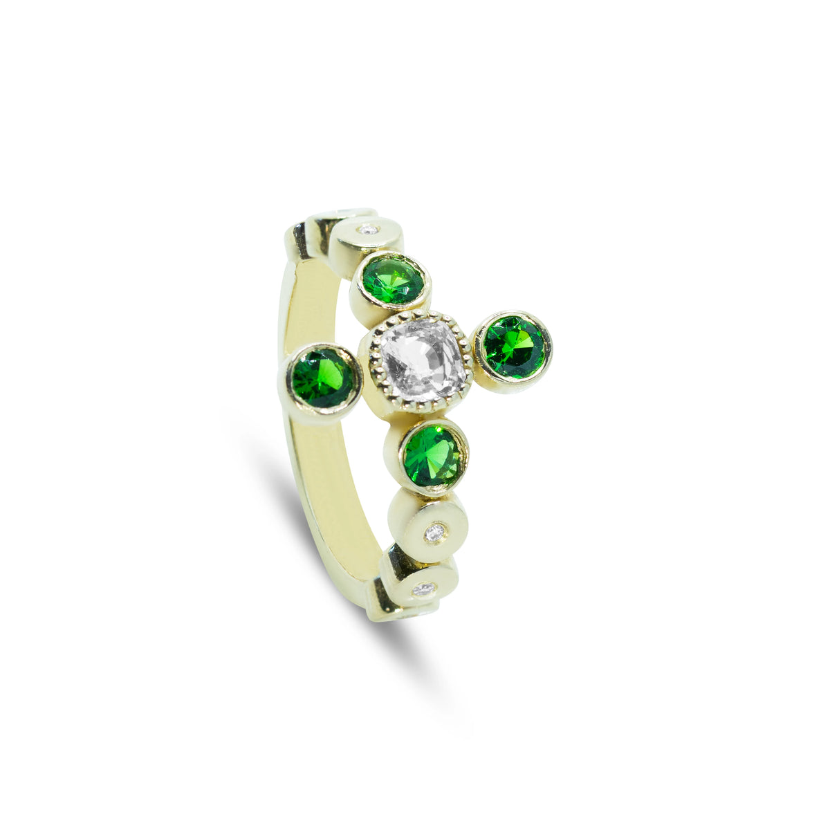Side angle of an 18ct white gold ring showing the vibrant green tsavorite stones and natural diamond accents.