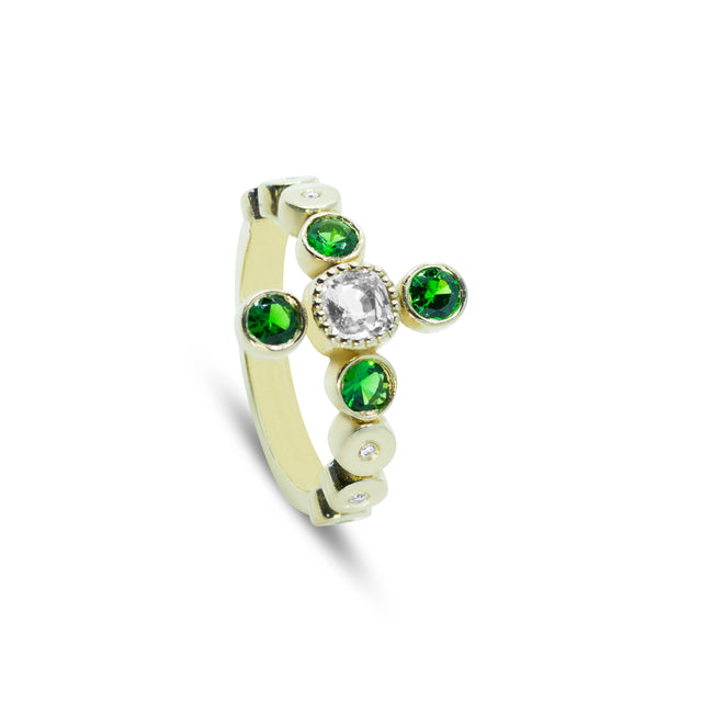 Side angle of an 18ct white gold ring showing the vibrant green tsavorite stones and natural diamond accents.